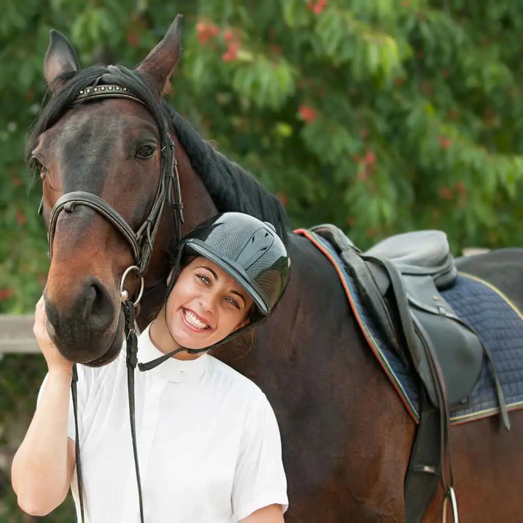 Woman standing under horses head - just horse riders