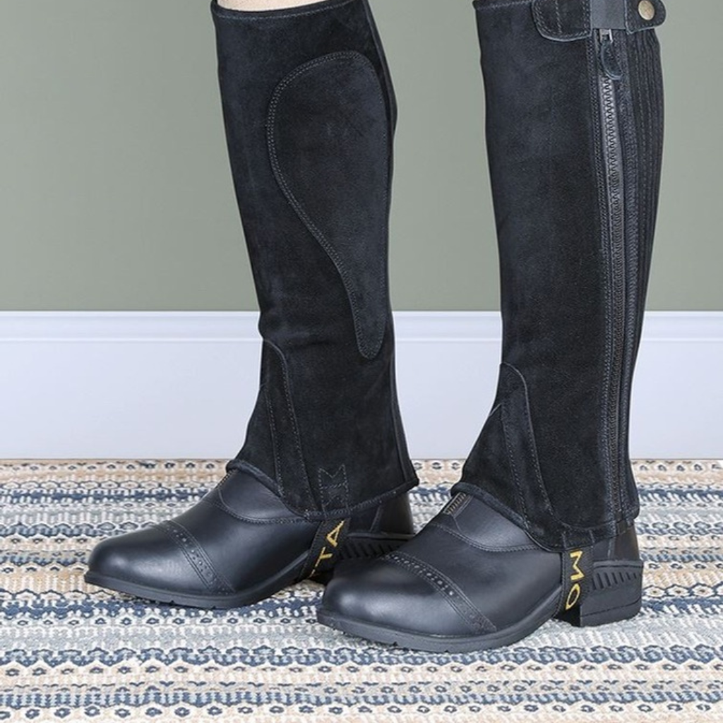 Child's legs in grey suede half chaps over jodhpur boots